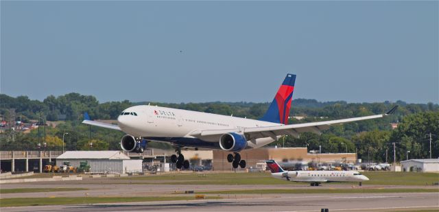 Airbus A330-200 (N858NW) - Delta 261 heavy about to touchdown on runway 30L, while a Flagship CRJ waits to depart.