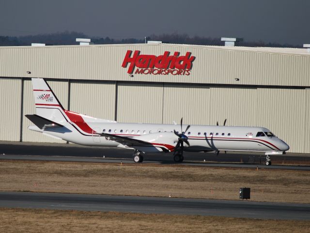 Saab 2000 (N517JG) - Joe Gibbs Racing team plane taxiing in front of the Hendrick Motorsports hangar at Concord Regional Airport (Concord, NC) - 2/7/09