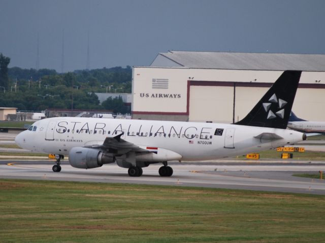 Airbus A319 (N700UW) - Taxiing across 18C/36C to terminal. Whats up with the red, white, and blue stripes just behind the wing? - 7/19/12