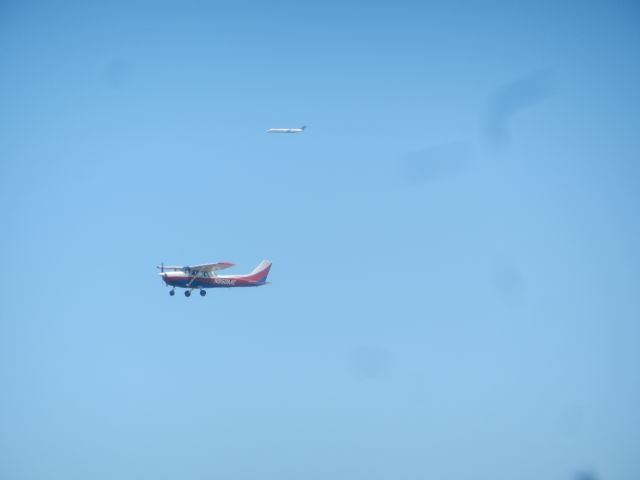 Cessna Skyhawk (N950ME) - A Training Cessna 172 Takes Off As A Delta MD-88 Approaches Dulles Overtop