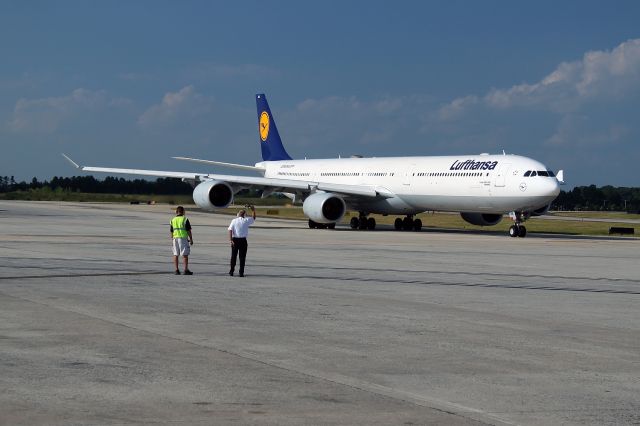 Airbus A340-600 (D-AIHA) - Auf Wiedersehen.The big Airbus 340 begins its taxi to the runway. In a traditional ground crew gesture, the Lufthansa Chief Technician waves farewell. This is the afternoon flight - #429 from Charlotte, North Carolina USA to Munich. The aircrafts name is Nurmberg.