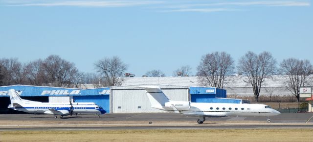 Gulfstream Aerospace Gulfstream V (N845CB) - On the right taxiing to the hanger is this 2015 Gulfstream 450. A pair of Freight Runner Express Saab-Scania 2000's enjoy some tarmac time on the left in the Winter of 2023.