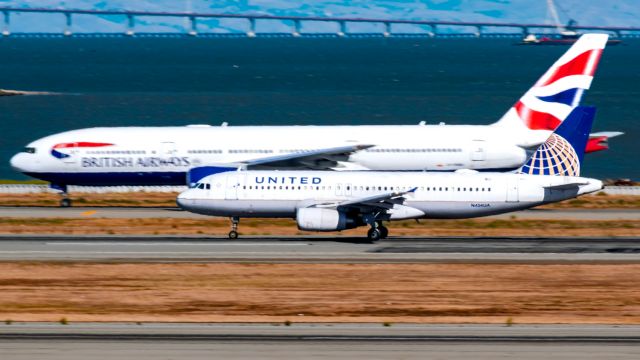 Airbus A320 (N454UA) - United A320 speeding past a Speedbird B772 holding on the parallel taxiway at KSFO.