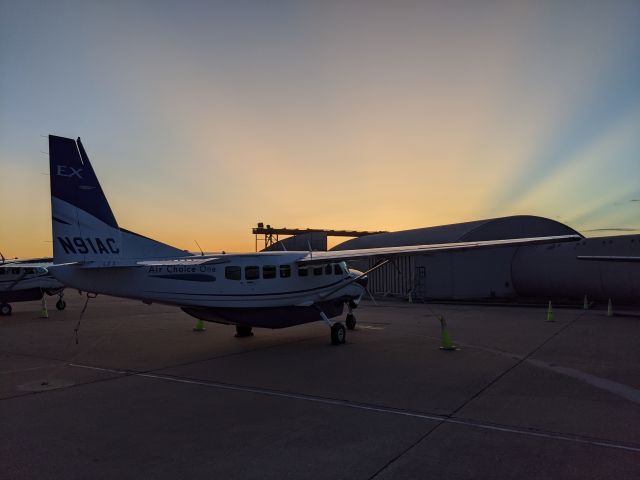 Cessna Caravan (N91AC) - The sun setting on the hangar in STL with N91AC on the tie-down.