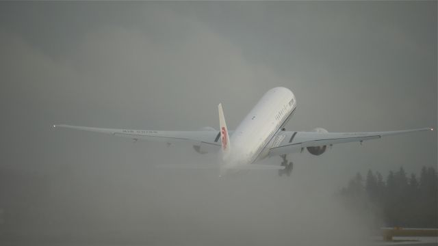 BOEING 777-300 (B-2043) - BOE166 climbs from a wet Rwy 16R just after a heavy rain squall has moved across the airport on 8.29.13. (LN:1132 cn 41441).