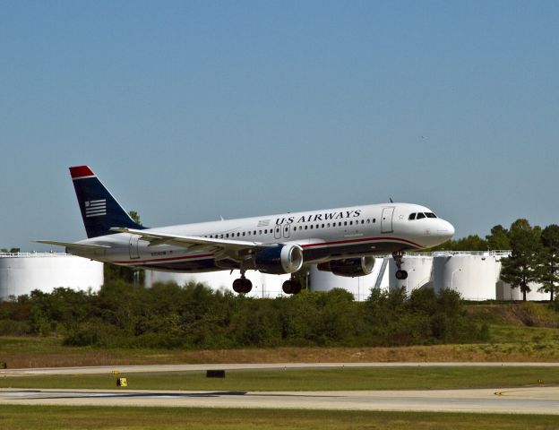 Airbus A320 (N104UW) - Afternoon arrival on runway 18C, Charlotte, North Carolina. A short visit and its off to San Francisco, California (SFO). View at "full" and notice that the right engine cowl is a replacement that has to be re-painted the correct colors.Right engine inlets are prone to damage by baggage handling equipment because even when a belt loader is properly lined up to unload the forward bag bin, its still very close to the inlet. They are also removed for maintenance problems.