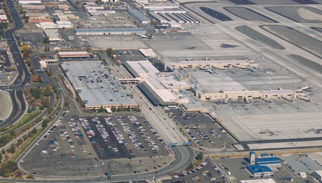 — — - Snapped while flying directly above runway 7-25, this click is a capture of the main terminal (named in honor of Howard Cannon) and Concourses "B" (lower) and "C" of Reno Tahoe International.br /The surface parking lot seen in the lower left center of this picture (directly below the three-story parking structure) is where the terrible crash of N821ET, a Piper, occurred about 5 months ago on Sunday, September 11 (2016).  The P28R, with three on board, had just taken off from runway 25 when it failed to continue its climb, veered to the right, and impacted into that parking lot (roughly about where the middle row of cars are parked in this shot).  The Piper came within 600 feet from striking the main terminal building, and there are some of us who feel that the pilot saw his craft was heading toward the terminal and as his last action brought the plane down in the lot instead.  Tragically, there were no survivors in the Piper.  No people on the ground were injured or struck, but 15 cars were heavily damaged or destroyed.br /N821ET was departing for a flight to KSQL (San Carlos, CA).  FlightAware still displays its final flight plan from RNO to SQL and even shows it departing RNO just seconds before the fatal crash.