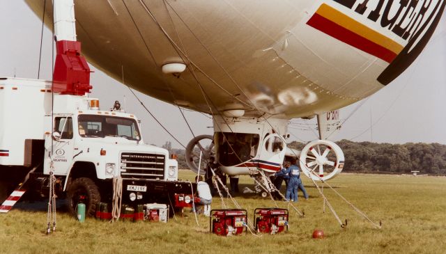 G-BIHN — - I took this image about 1984 at Panhanger Aerodrome UK. Skyship 500. length 50m, height 18.5, envelope volume 181,198.5 ft3 - passengers 10, power 2xPorsche 930/10, max endurance 25 hrs, max speed 60 knots, lift by helium. Original print lost some color but it seems like yesterday I took the image. Piper Tomahawk from flying school landing behind