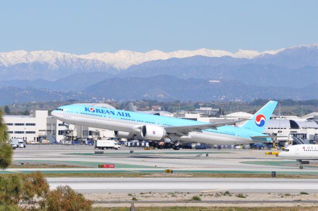 Boeing 777 (HL7784) - Korean Air 777 takes off at LAX.  The Hollywood sign can be seen in the distance.