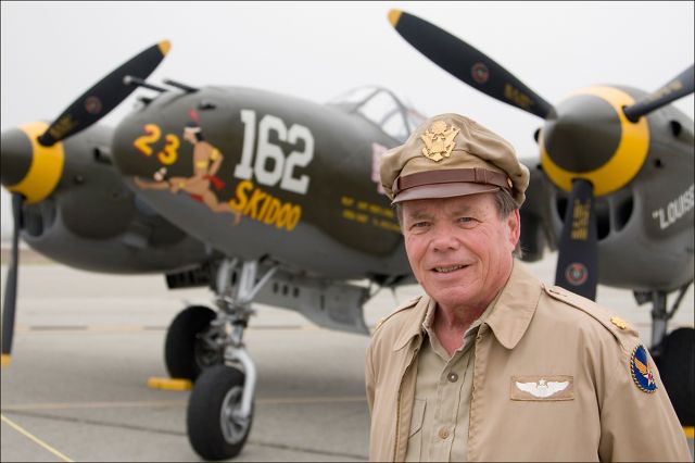 Lockheed P-38 Lightning (N138AM) - A friend in WWII Army Air Force uniform poses for a portrait in front of the Planes of Fame air museums Lockheed P-38 Lightning.