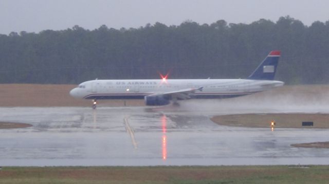 Airbus A321 (N323AW) - U.S. Airways 2013 arriving at 5:20 P.M. from Charlotte.  Taken March 19, 2015 during a steady rain.