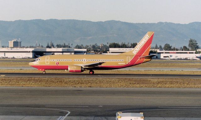 BOEING 737-300 (N301SW) - KSJC - Early 1990s photo from the old Observation deck at San Jose "The Spirit of Kitty Hawk" on taxi for 30L and departure. SWA didn't start serving SJC until about 1994, so this was in that time frame. Ln 1048 delv new to SWA Dec 20, 1984 as first flight to delivery was about 2 months..