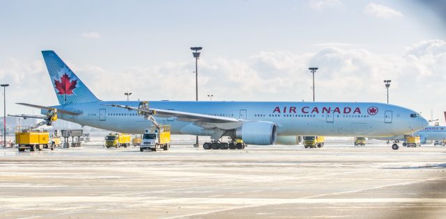 BOEING 777-300 (C-FIVM) - Getting a splash of de-icing fluid before departure to Hong Kong Intl as ACA15