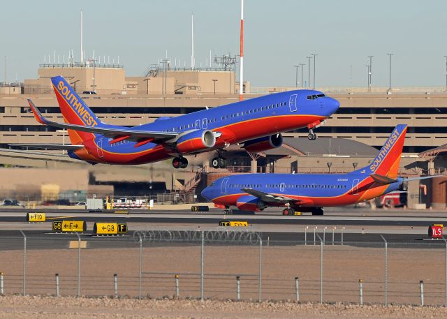 Boeing 737-800 (N8648A) - Both ends of the spectrum for Southwest. N8648A (737-8H4) is taking off from 7L is 1.6 Y/O (8/19/2014) while N345SA (737-3K2) is 28.8 Y/O and is taxing to the active. 
