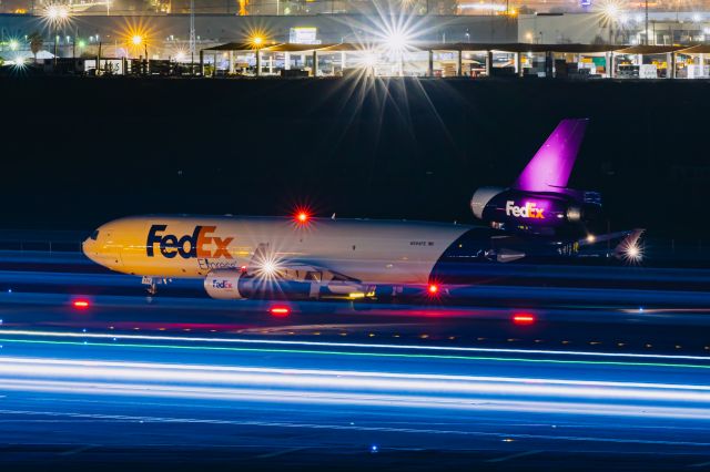 Boeing MD-11 (N594FE) - FedEx MD11 taxiing with an American Airlines 737-800 turned into a bright streak of light from the 20 second exposure at PHX on 12/10/22. Taken with a Canon R7 and Tamron 70-200 G2 lens.