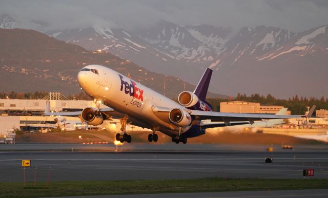 Boeing MD-11 (N572FE) - N572FE late evening departure in golden hour light, departing runway 33 in Anchorage, AK. 