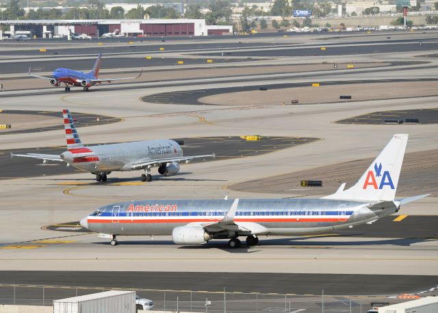 Boeing 737-800 (N940AN) - N940AN is taxing on S while a sister American A321 (N510UW) is taxing on D and a Southwest 737 (N204WN) is taking off from 7L.