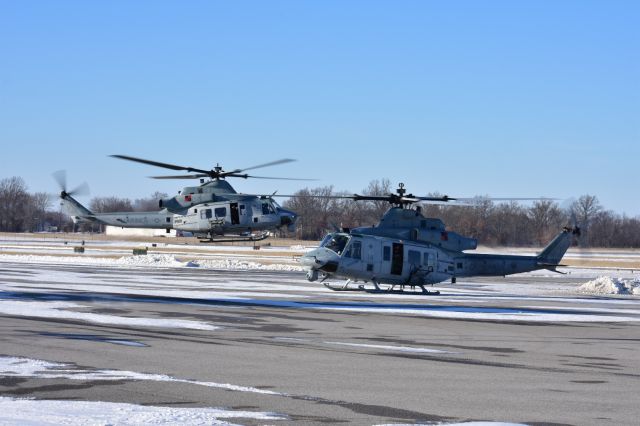 — — - A Pair of Hueys one departing and one preparing to depart the ramp