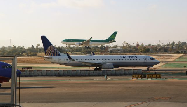 Boeing 737-800 (N38467) - 6/28/18 United taxiing out to Rwy 24L as an Aer Lingus prepares to touch down on Rwy 24R