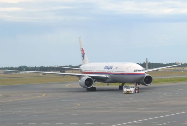 Boeing 777-200 (9M-MRE) - Being towed by tug from a remote stand to gate 18 at Terminal 1, to prepare for return flight to Kuala Lumpur.