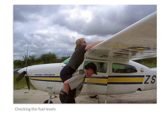 Cessna Centurion (ZS-AVB) - Checking the fuel on a C210 without a ladder is always  challenge... In the Okavango Delta, Botswana, Africa.