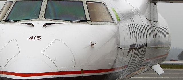 de Havilland Dash 8-400 (N415QX) - Trying something a little different here after the rain came and started falling. I like the way the rain shines on the Fuselage on this shot. Also notice the reflection of the prop just infront of the door.