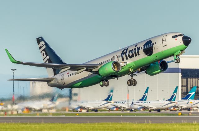 Boeing 737-800 (C-FFLC) - This Flair 738 blasting off runway 06L. Some parked Westjet birds in the background!