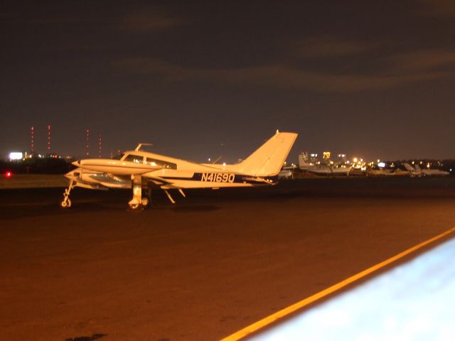 Cessna 310 (N4169Q) - Sitting at Birmingham International at night with downtown Birmingham in the background.