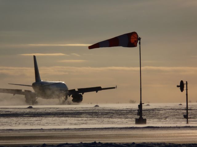 Airbus A319 — - landing on rwy #25, with winds gusting out of the north at 20-30 kmh. As evident by the wind sock.