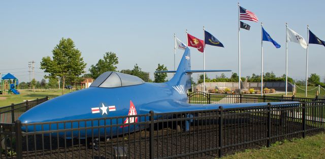 — — - On display here since the later 1950s, this Grumman F9F-6P Cougar is known by residents of the Tonawanda, NY, area (Town of Tonawanda, City of Tonawanda) as the "Blue Jet." br / Recently repainted for the umpteenth time, the Cougar is now (as seen here) protected by a small fence and stands at the entry point to the Veterans Memorial Park at the intersection of Brighton and Colvin Avenues in the Town of Tonawanda, New York.  Somewhere under this newest coat of paint are my initials, scratched on in the early 1960s.  br /The identifying numbers of this aircraft are not known.  Back in the 50s, the US Navy donated this jet for display.  Over the next decades, the data regarding it became lost, the aircraft was painted and then repainted, etc., and today this aircraft is now unidentifiable.  The paint scheme on the "Unknown Cougar" does not represent any specific livery ever used by the United States Navy, and I have no doubt that the "Blue Jet" I used to crawl on when I was ten and eleven years old will be there when Im nothing more than ashes in the air.  (Salute)