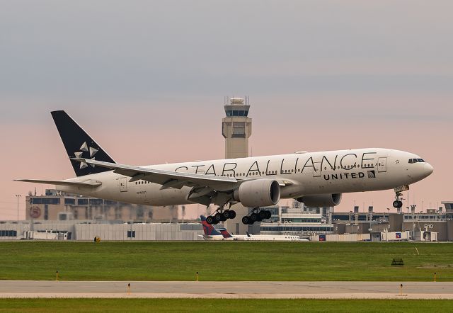 Boeing 777-200 (N76021) - UAL 3812Heavy, a Boeing777 224(ER), with the Star Alliance livery, arriving on RWY 24R early Sunday morning, 25 Aug 2024. This was a charter flight carrying the Cleveland Browns back from a late-night flight from Seattle-Tacoma Intl (KSEA). The pink colors are courtesy of an approaching thunderstorm.