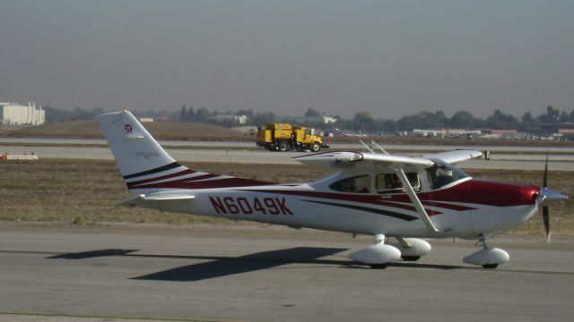 Cessna Skylane (N6049K) - Taxi after landing.  Taxiway Bravo toward Golf from Delta.  note: the sweeper in the back ground is picking up after a B-52 that blew a massive amount of FOD on taxiway Delta during taxi to Rwy. 30 before takeoff.