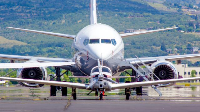 Boeing 737-700 — - A Bonanza parked in from of a private B737 in Medford. 