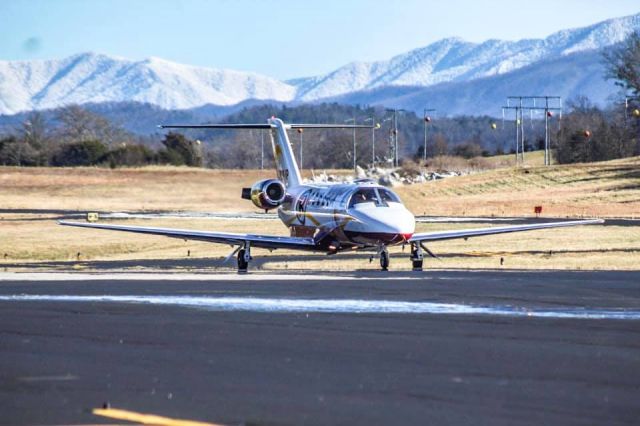 Cessna Citation CJ2+ (N878JP) - N878JP taxiing to the FBO after landing on R10. Complete with the snow covered smokies in the background.