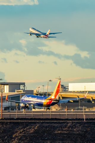 Boeing 737-700 (N7823A) - Southwest Airlines 737-700 landing while an American Airlines 777-200 takes in the the background at PHX on 12/13/22. Taken with a Canon R7 and Tamron 70-200 G2 lens.