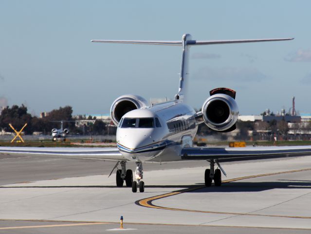 Gulfstream Aerospace Gulfstream V (N940AJ) - This G-V taxiies to 30L for departure and tests his left reverser, while an HP G-V taxiies to the FBO.