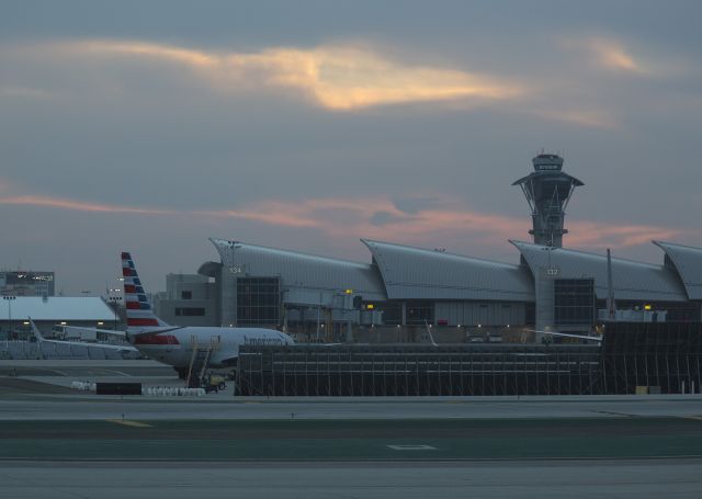 Boeing 737-700 (N929NN) - Sunrise at LAX, Los Angeles, California USA. I thought the light was interesting because of the sheen it gave the international terminal. The LAX Control Tower looks menacing in the grey, greasy-looking morning light. br /br /To you low voters-get your butts out of bed way before the crack of dawn and get down to your airport and see what you can do. I know, too dark, too cold, too cloudy, too hung-over, airport is too far away...I couldnt help noticing that I was the only guy out there taking photos. You definitely werent there.