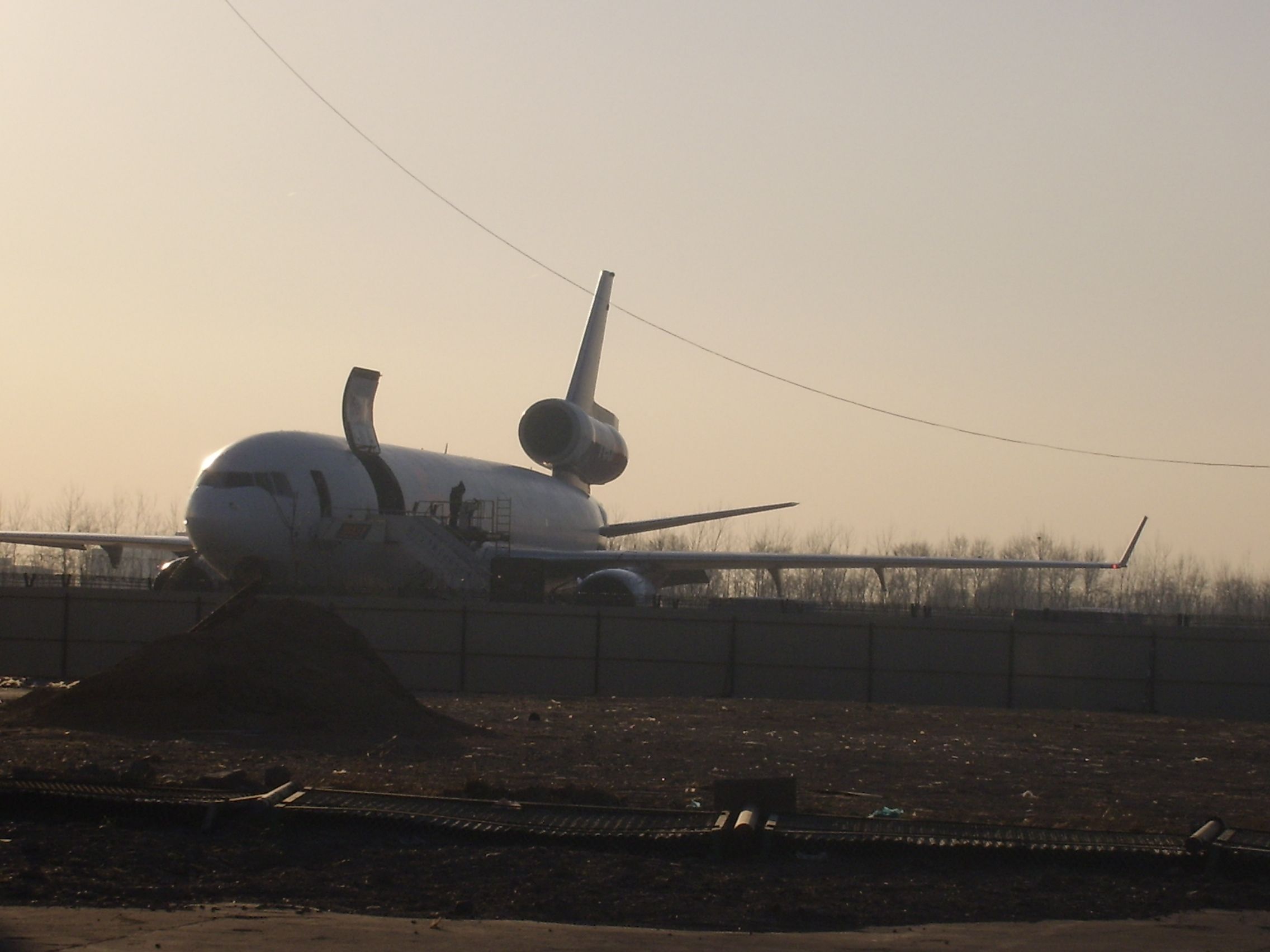 — — - Fed Ex plane loading up at the farthest  corner of the airport by all the construction.