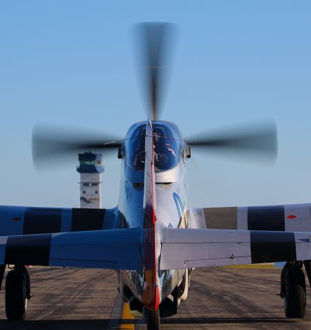 North American P-51 Mustang (N551J) - On an early Sunday morning at the Sun N Fun aerospace expo at Lakeland Florida this P51 was towed to the ramp for departure. After preflight checks the pilot had just started the engine. Since it was so early, I was able to get right behind the P51 for this shot. However I had to chase my ball cap down after taking a few photos. It is my understanding that NASCAR's Jack Rousch owns this beautiful warbird. I shot this with my Canon 70-200 F2.8 lens at the focal length of 70mm. The shutter was 1/125, F13, ISO 100. Please check out my other aviation photography. Votes and positive comments are always appreciated. Questions about this photo can be sent to Info@FlewShots.com