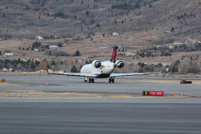 Canadair Regional Jet CRJ-700 (N713EV) - N713EV taxiing to runway 12 at Butte as SKYWEST 4312 to KSLC.br /br /Taken 18:07, November 2, 2024 with a Canon EOS T2i and 70-300mm (140mm, 1/200, ƒ5, ISO 1600)