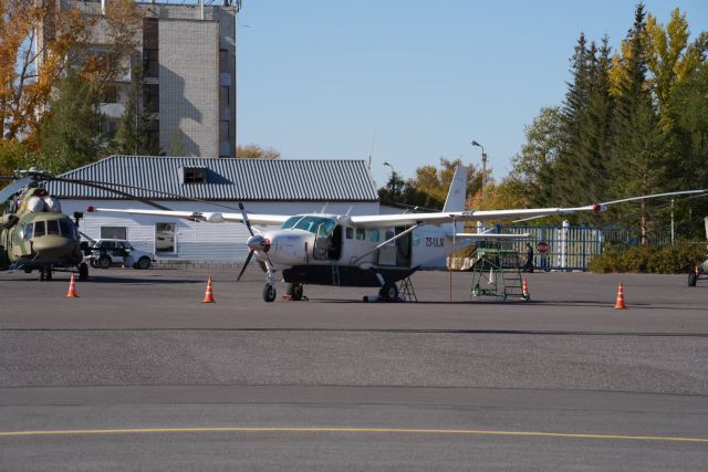 Cessna Caravan (ZS-ULM) - A South African registered 208 Grand Caravan sits mysteriously amongst Russian Mi-8s at UAKK.