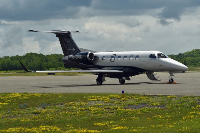 Embraer Phenom 300 (C-GRIA) - 2020 Embraer EMB-505 Phenom 300 (C-GRIA/50500566) with potential storm clouds in the background. Photo taken June 30, 2021.