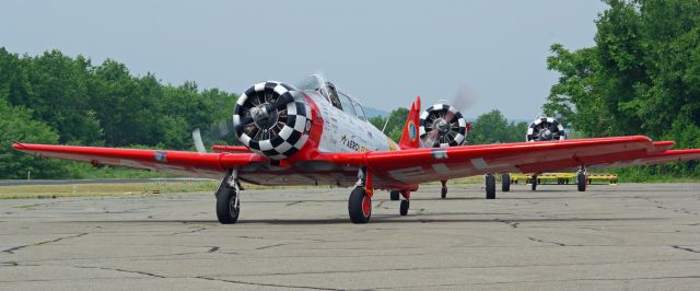 North American T-6 Texan (N77055) - GREENWOOD LAKE AIRPORT, WEST MILFORD, NEW JERSEY, USA-JUNE 11, 2023: Seen by RF at the 2023 Greenwood Lake Airshow was the Aeroshell Aerobatic Team. This team flies four AT-6 Texans. Here we see three of the four planes taxiing for take off.