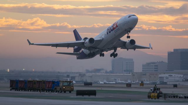 Boeing MD-11 (N610FE) - A clean FedEx MD-11 departs LAX early Saturday morning. The not so clean looking tug and bag carts in the lower left belong to Southwest. 10 Jan 2014