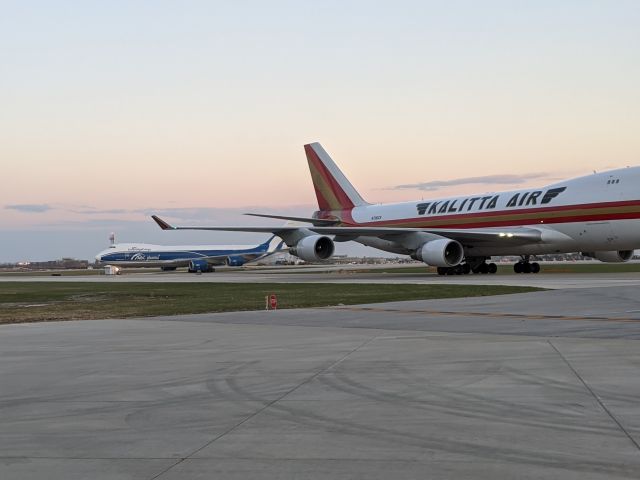 Boeing 747-400 (N706CK) - Kalitta Air 747-400 westbound on taxiway D near Rescue Fire Station #2, followed by an Air Bridge Cargo 747-800  taxing to Northeast cargo.