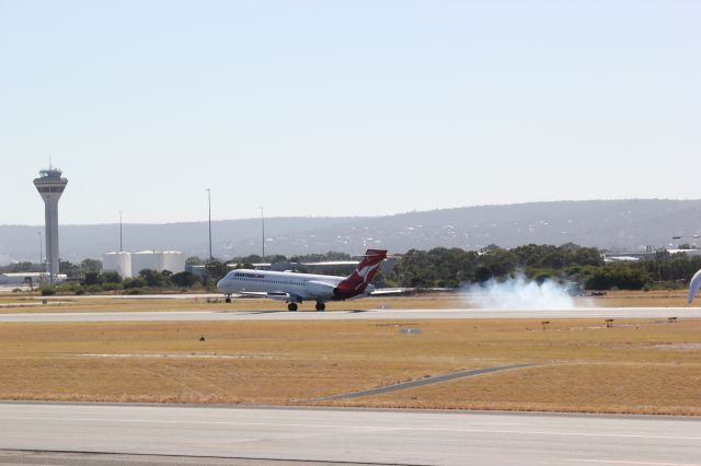 Boeing 717-200 (VH-NXG) - Smoke after tyres hit the ground from the under carriage