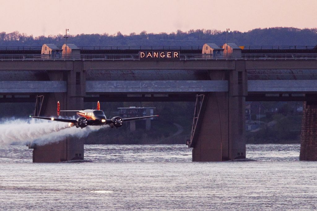 Beechcraft 18 (N9109R) - Beech 18 flying over the water at sunset during Thunder Over Louisville.