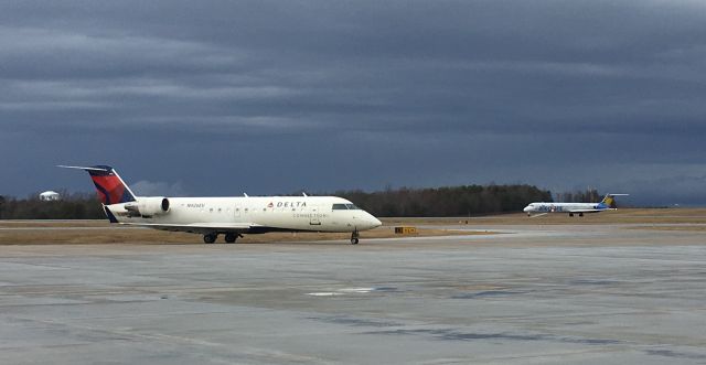 Canadair Regional Jet CRJ-200 (N926EV) - A warm December day with some ominous clouds approaching. Allegiant MD-83 rotating behind.