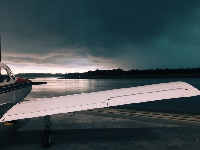 — — - A Beechcraft Musketeer sits out a incoming storm in the hangar