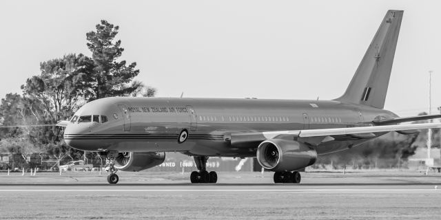 Boeing 757-200 (NZ7572) - One of our 2 gorgeous Royal New Zealand Air Force B752s about to line up on Runway 02 for a departure somewhere up in the North Island.br /On 20 July, the daily Emirates A380 had just landed from Sydney, and SOFIA, our part time NASA resident, Boeing B74S had just taken off, bound for Hawaii, and this sexy girl appeared on the taxiway. Here she is lining up on Runway 02.br /Shes painted a glossy light military gray, and with an awful mixed colour background and dull bluish sky, just had to be made into a contrasty black and white.